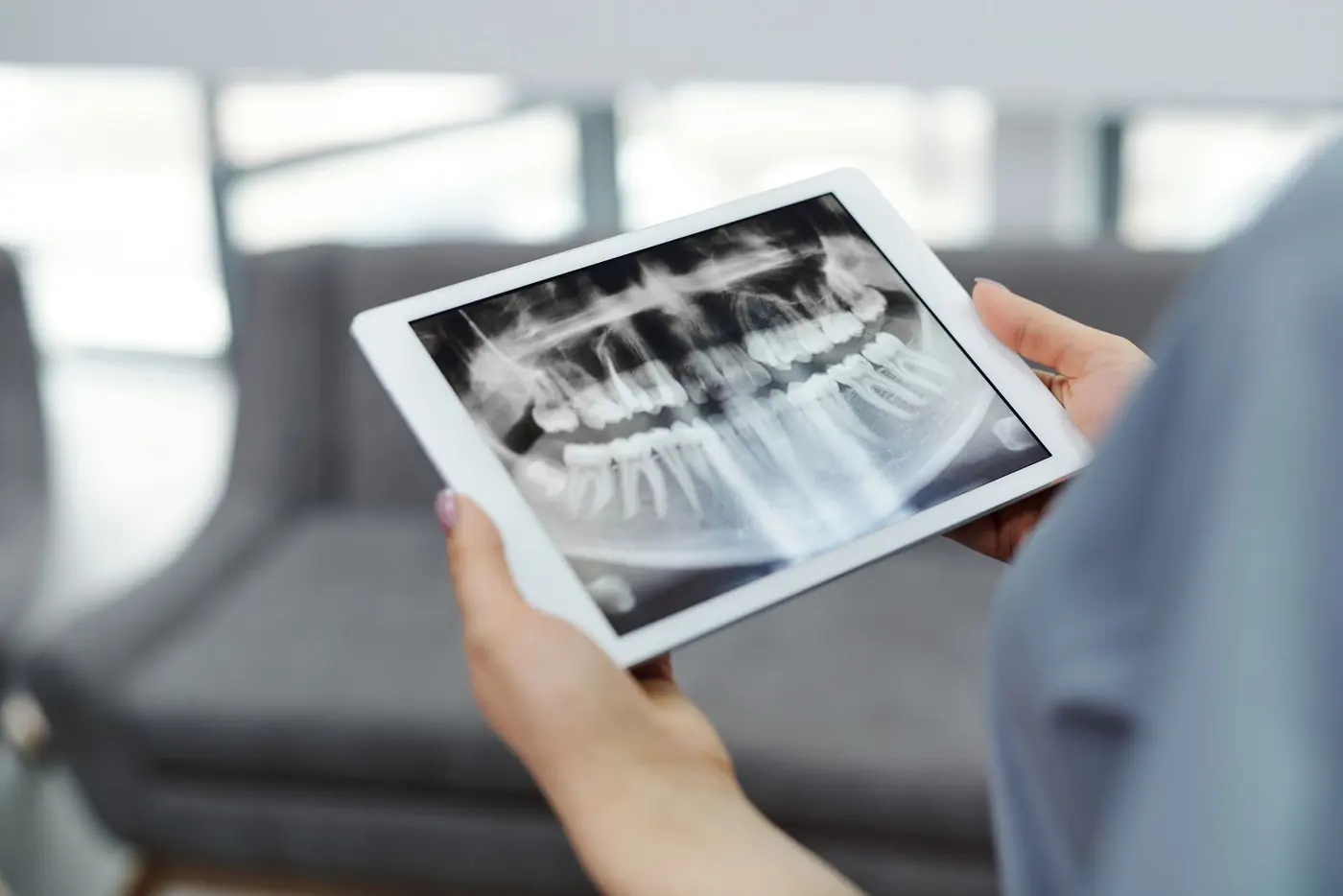 A dentist reviewing a panoramic X-ray on a tablet
